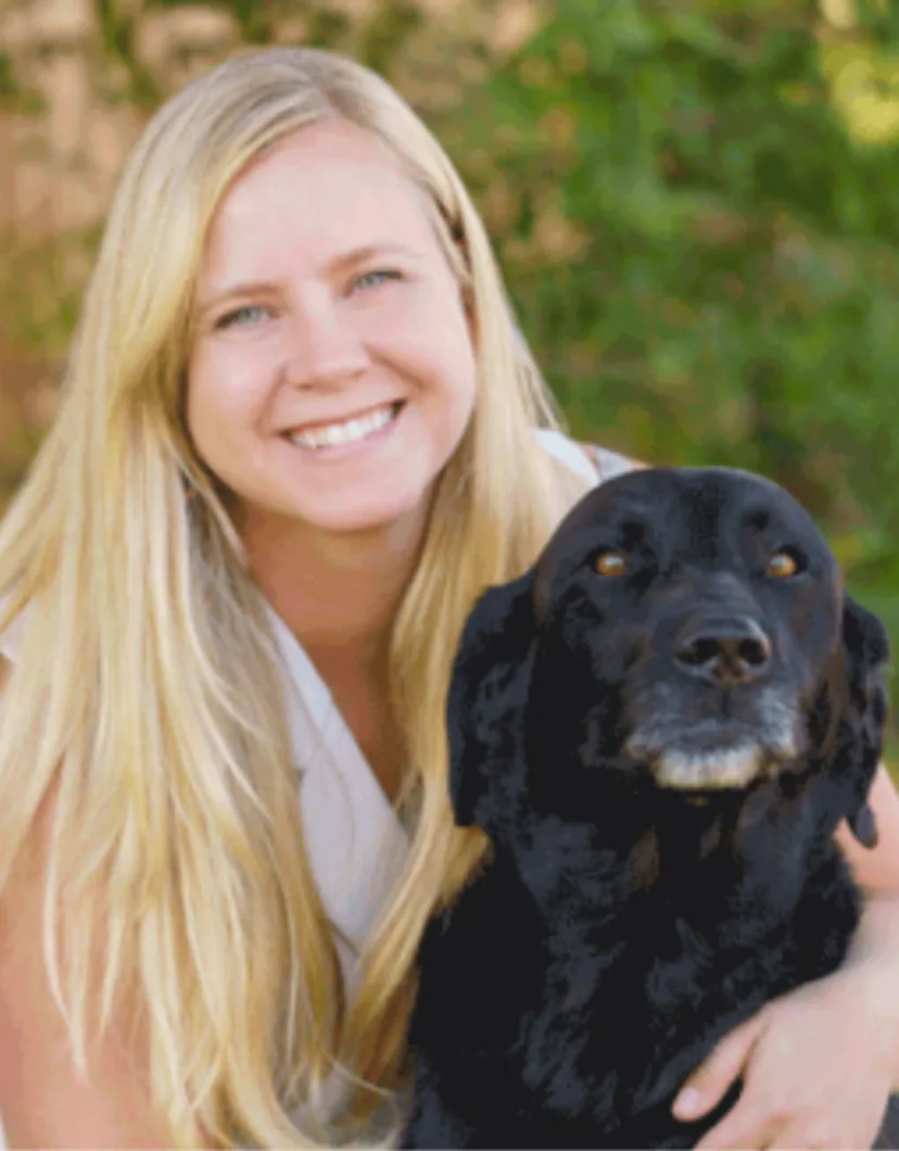 Morgan Domangue smiling and posing with a black dog